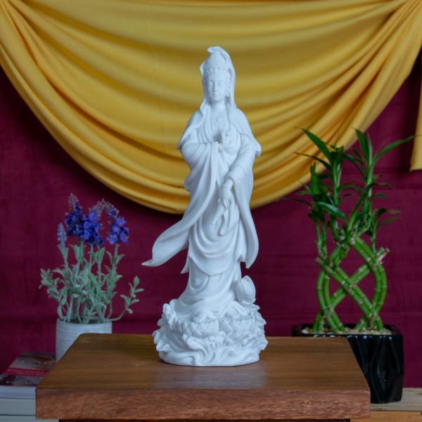 Estatua Kuan Yin parada sobre flor de loto